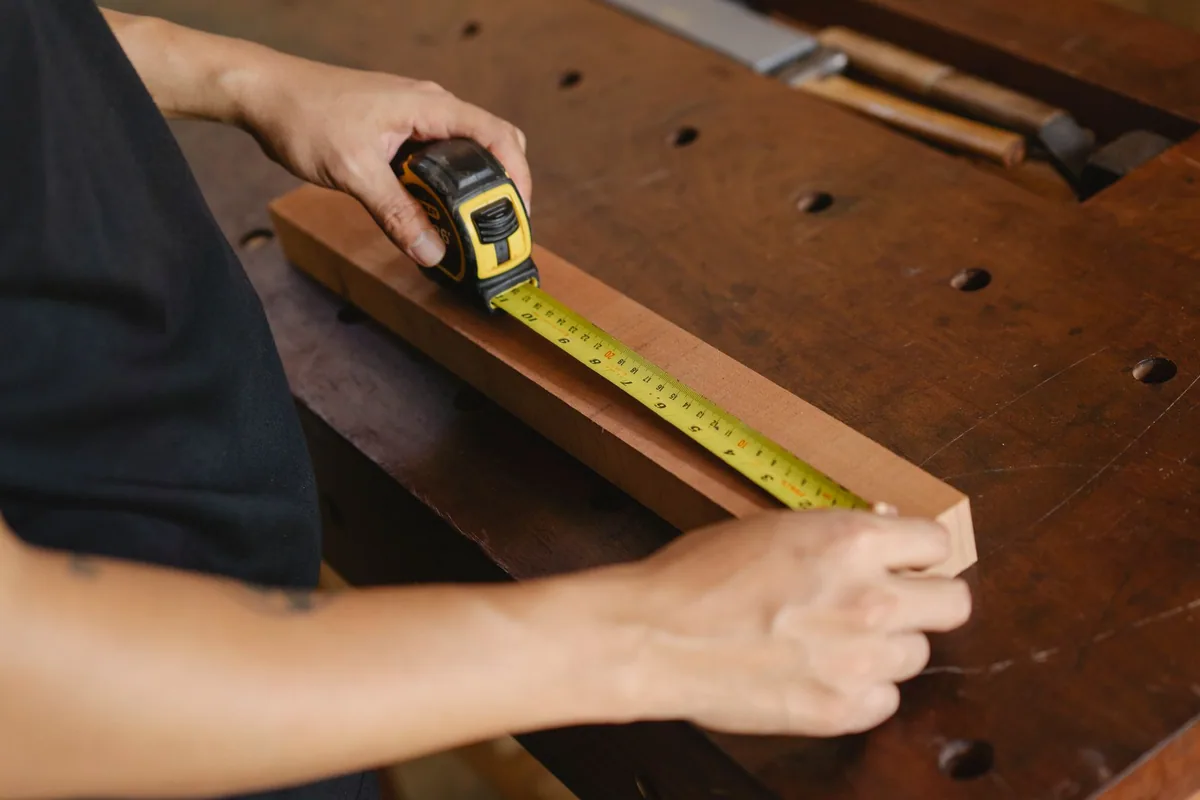 Manos aplicando adhesivo en una pieza de madera